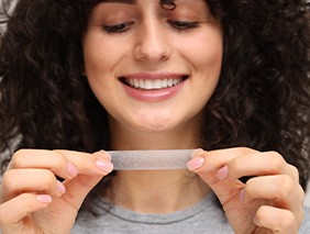 Woman holding a teeth whitening strip