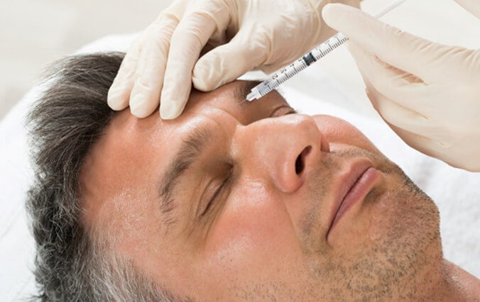 a man receiving cosmetic injectables in his forehead