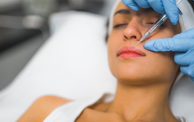 a man receiving cosmetic injectables in his forehead