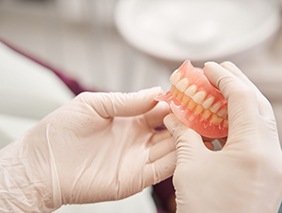 Person holding a set of dentures