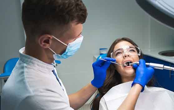 A dentist performing a root canal on a young woman